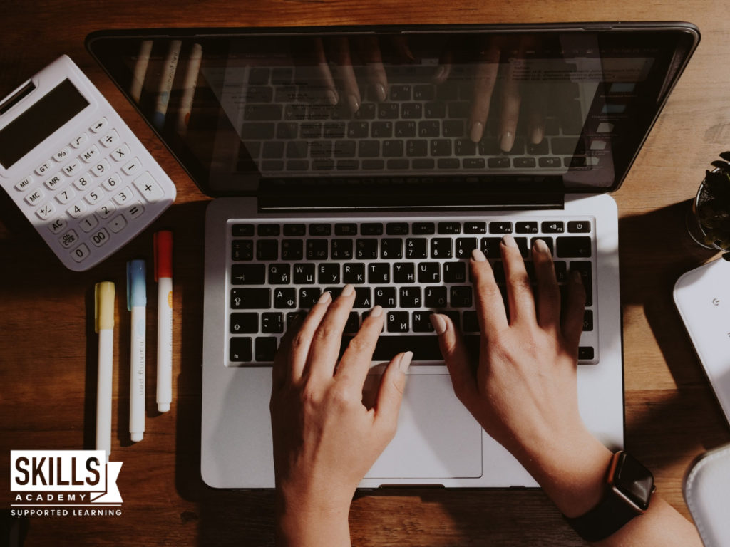 Accountant typing on a laptop with a few pens and a calculator on the desk. Study our accredited Accounting Courses today.