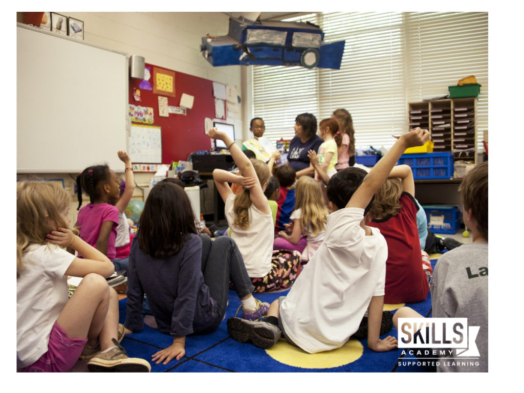 Group of children sitting on the floor in an Educare listening to their teacher: Study our Educare Courses Today