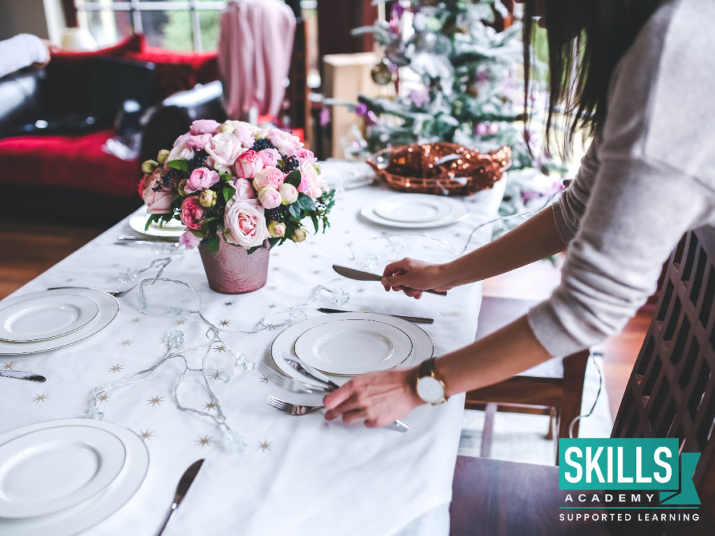 An events manager setting a beautifully decorated table. You can learn these skills with our Events Management Courses