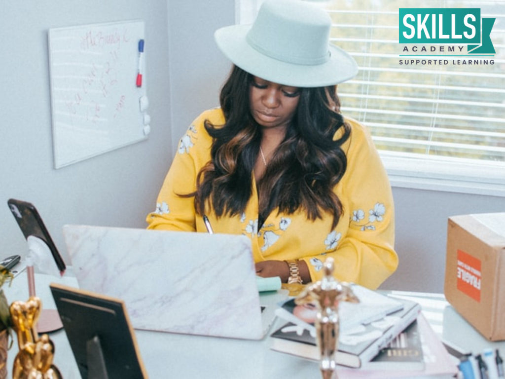 A girl sitting at her desk doing research on Facial Skincare Courses