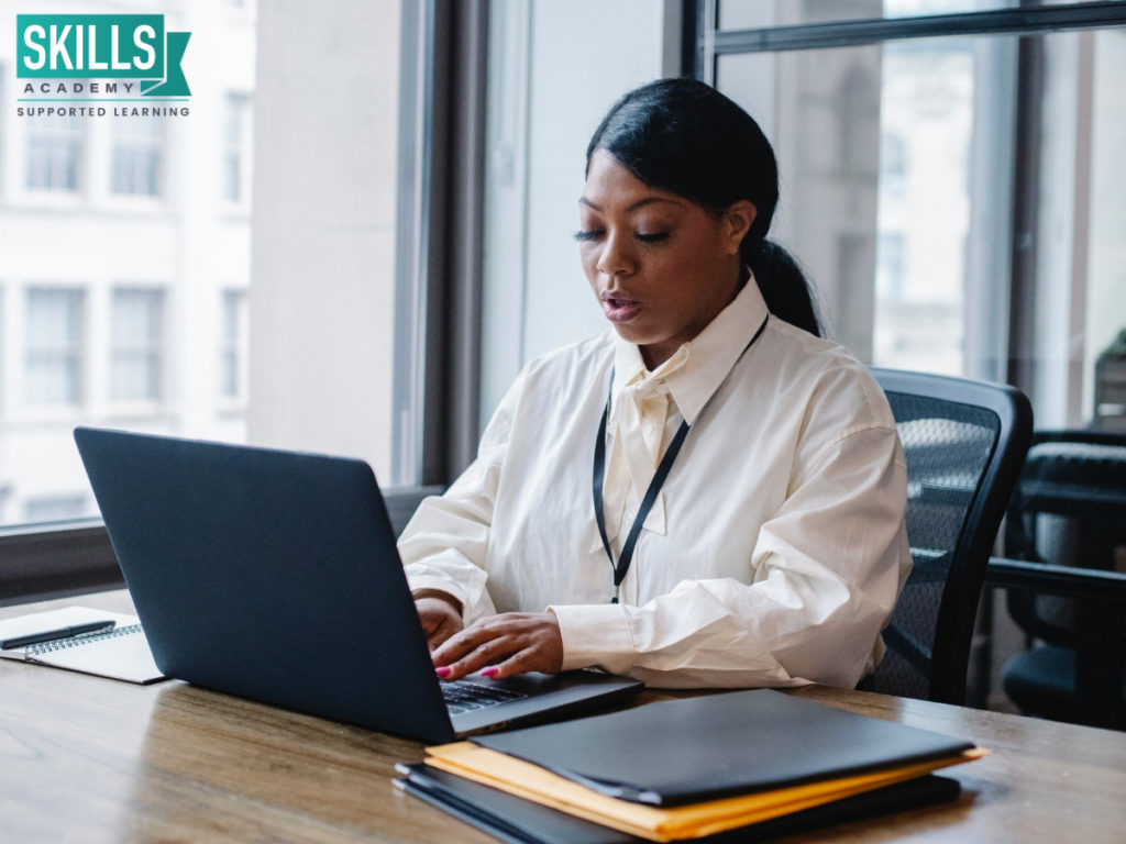 Secretary sitting at a desk typing on a laptop. Our Legal Secretary Courses will help you start a successful office career.