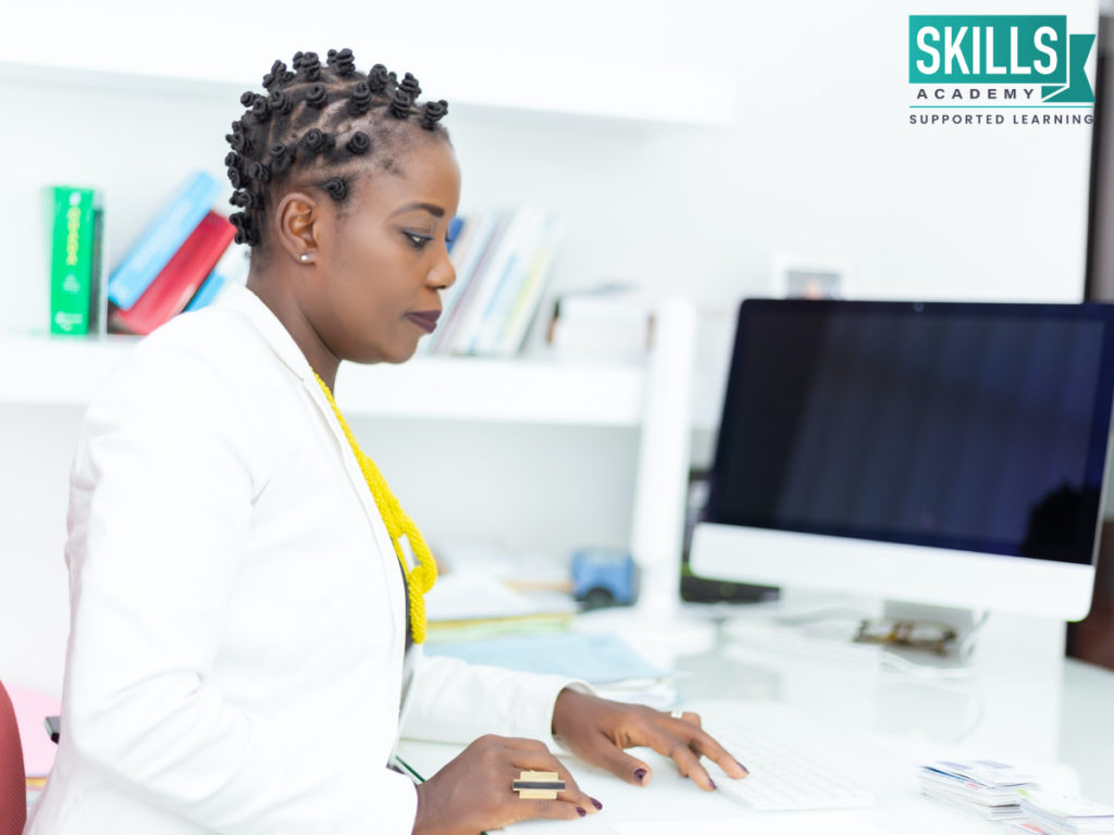 Woman stting at a desk doing paperwork. Study our Management Courses and improve your skills.