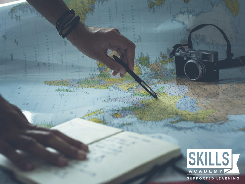 Person on a map with a pen and camera beside them. Our Tourism Courses will teach you valuable skills you need to thrive in the tourism industry.