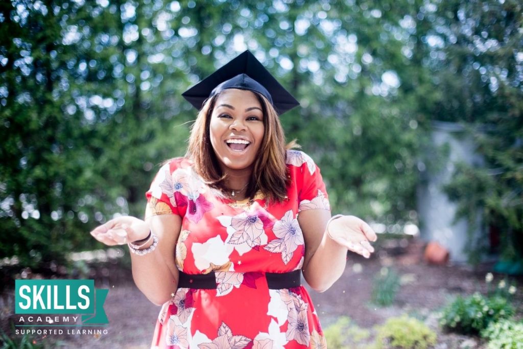 An excited student who got her CIMA Exemptions, standing happily with a red dress on and a graduation cap.