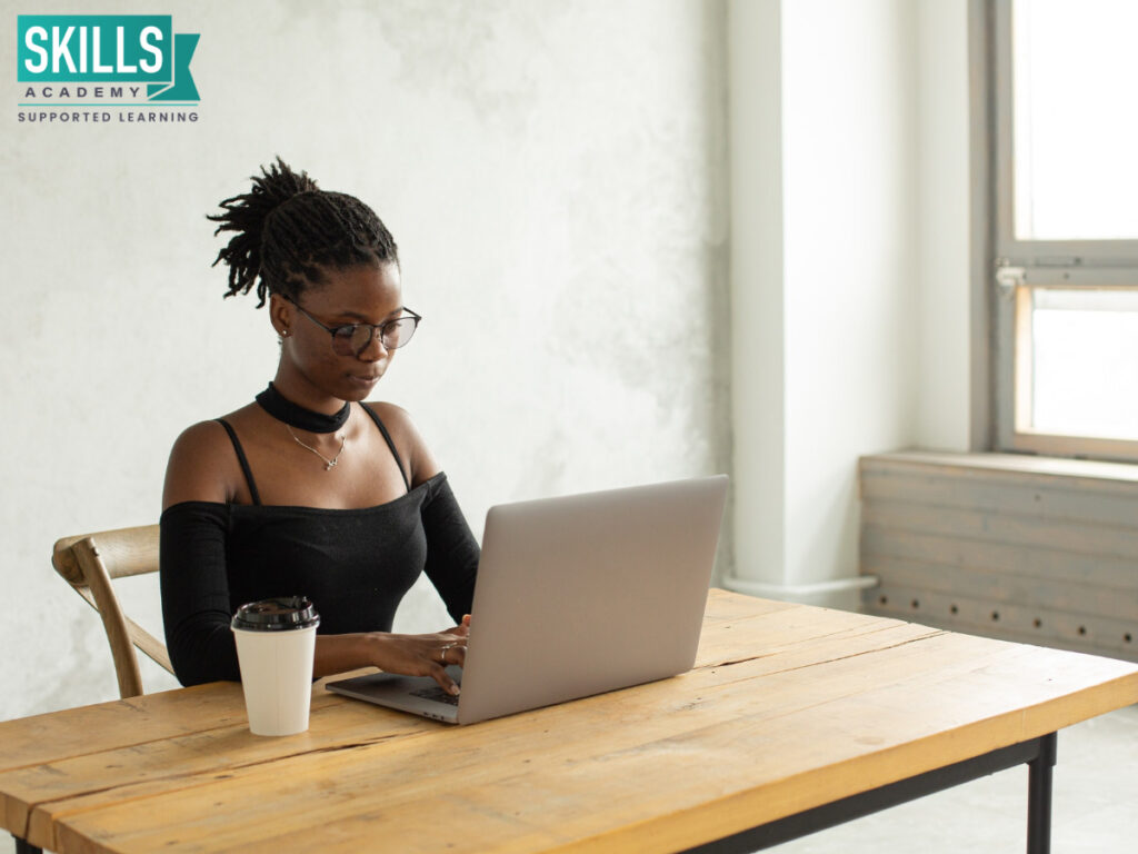 Woman sitting at a desk doing research on a laptop on choosing a courses to study.