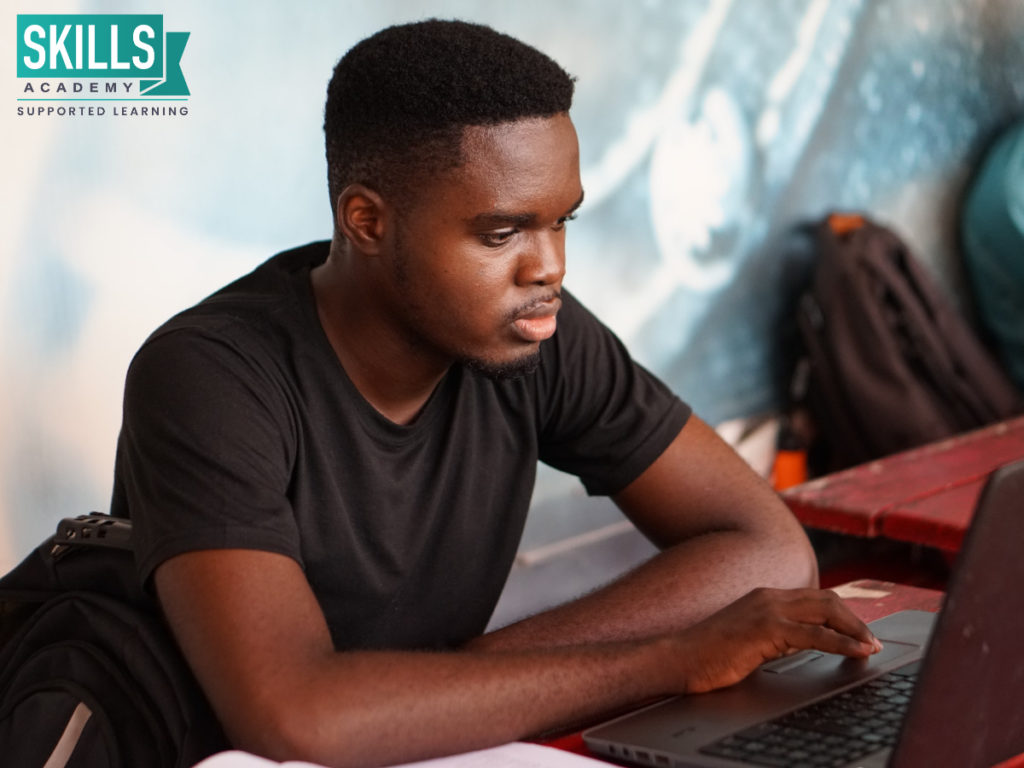 Man sitting at a desk, working on a computer studying one of our courses you can study without matric.