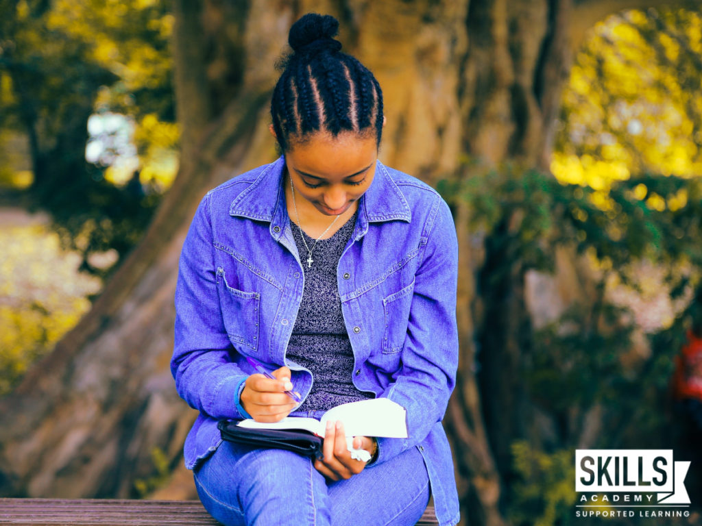 Woman sitting outside on a bench reading. Courses you can study without matric allows you to study from anywhere at your own pace.