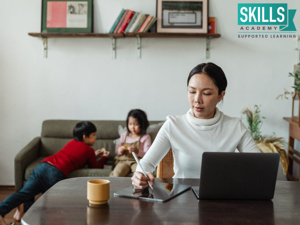 A working mom of two young kids sitting at a table with a laptop in front of her. Our Matric Courses for Adults makes it convenient to study, even if you have a family to take care of.