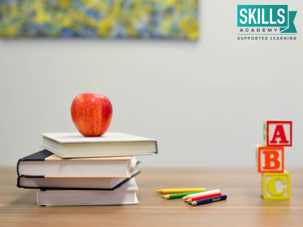 Four books stacked next to an apple and coloring pencils. Enable yourself with the skills and knowledge you need with our Educare and Child Care Courses.