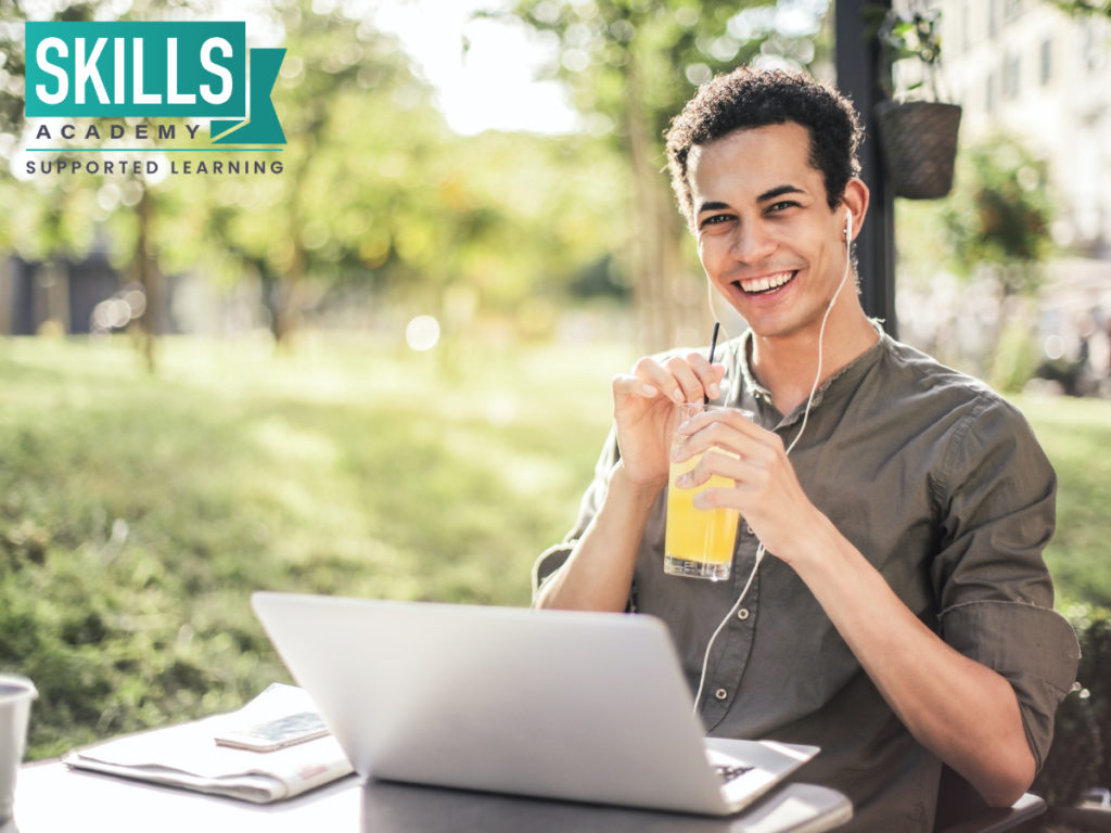 Man drinking juice while sitting with his laptop in a park.What can I Study With a Diploma Pass? Study diploma courses with us.