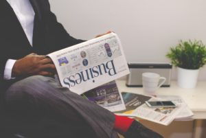 Business person reading the business newspaper to find information on Marketing Careers