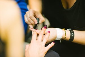 A Nail Technician doing a manicure. Learn these skills with our Beauty Courses.
