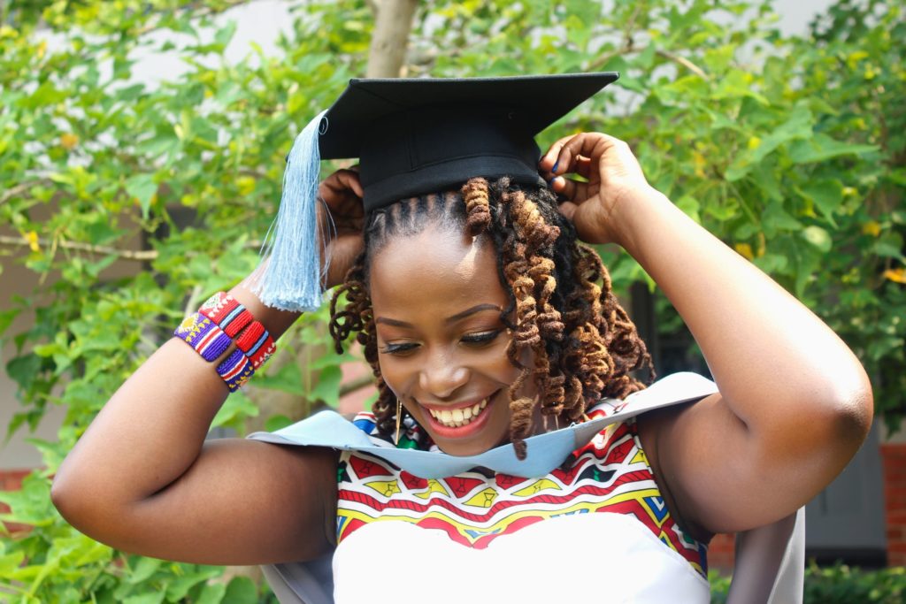 A young woman smiling happily on her graduation day because she doesn’t have to worry about her Study Fees.