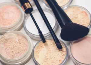 Make up brushes laid on top of nude make up powders