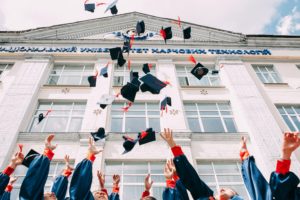 college students throwing their graduation hats in the air