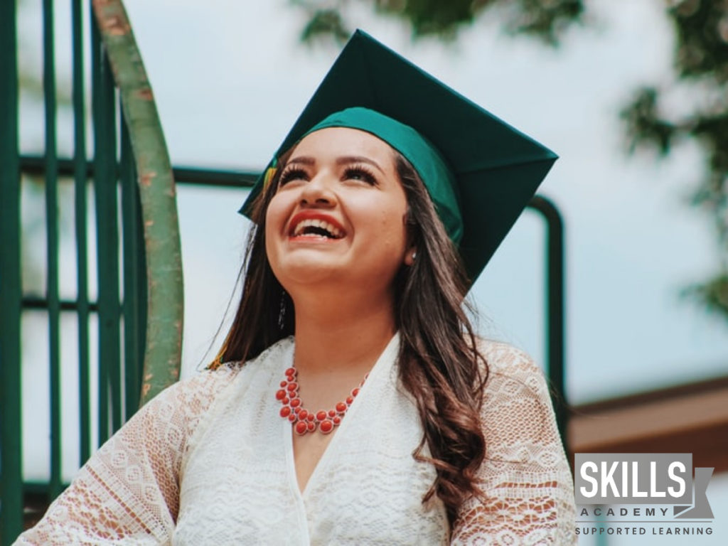 A young girl smiling up at the sky on her graduation who found out how to pass online courses
