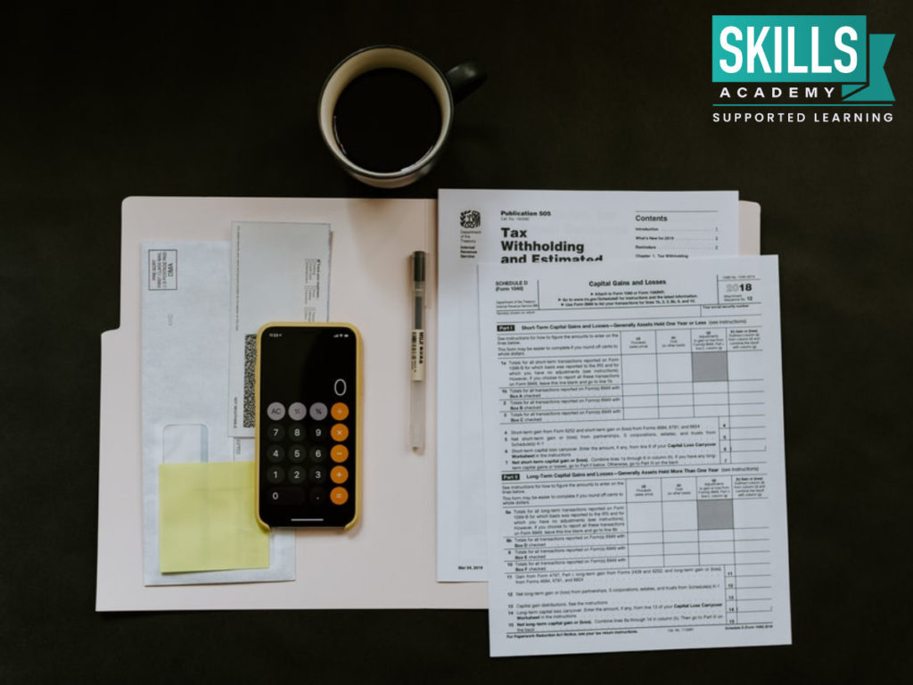 A few notes and calculator on a table and a coffee mug - All study materials you will use once you choose your course by knowing What are the Best Accounting Courses.