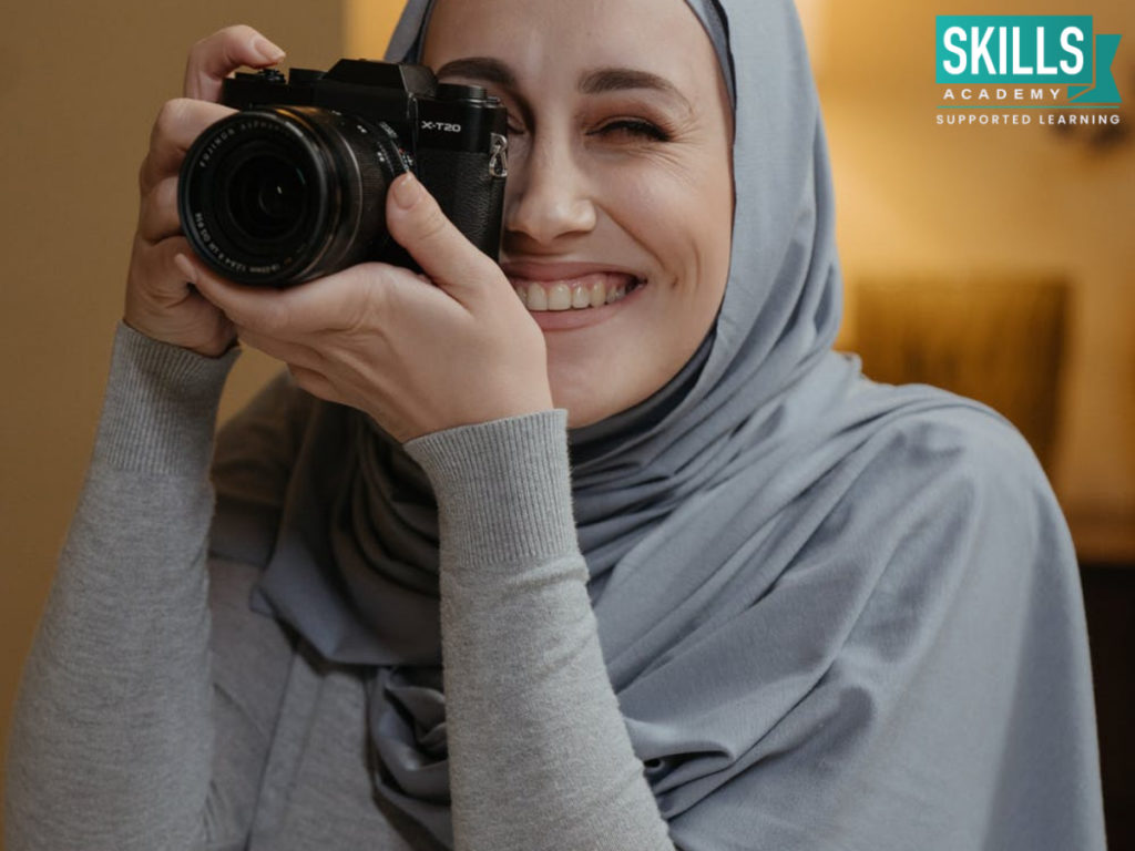 Woman wearing hijab practicing her photography skills in her room. Becoming a Professional Photographer can be hard, but with a lot of practice and determination you can succeed