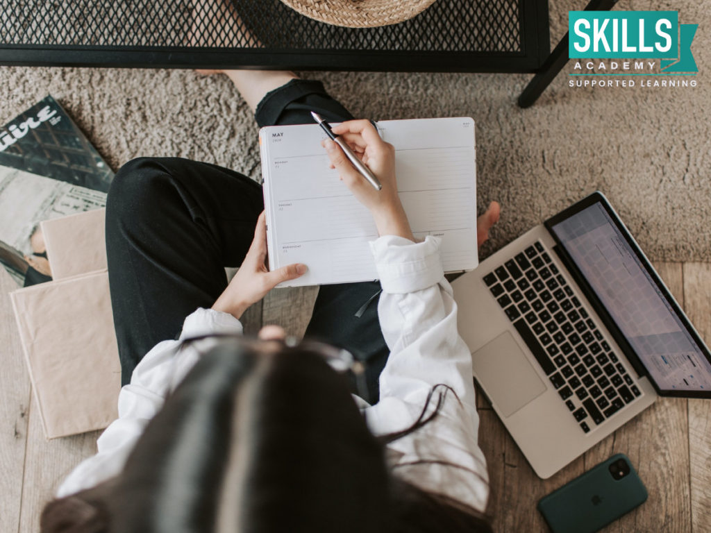 Female student writing down notes on How to Maintain Your Study Goals