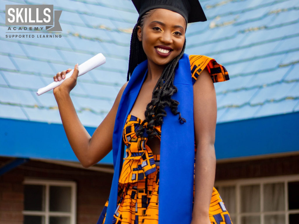 Graduate smiling with her diploma in her had shile standing in front of a building. You can be successful too if you know How to set Goals for the New Year.