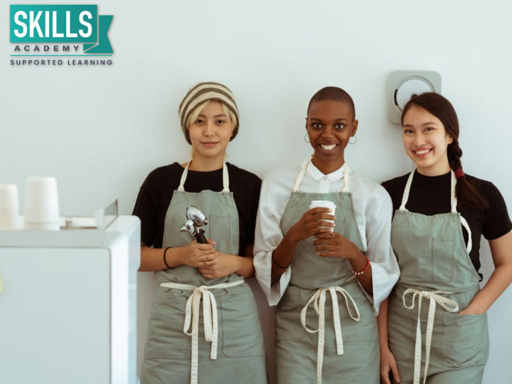 Three women in aprons working in their coffee shop. Can Anyone Become an Entrepreneur? With our courses you can get all the skills needed to start your small business.