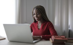 A woman smiling happily at her laptop because she found out about Useful Skills for any Career.