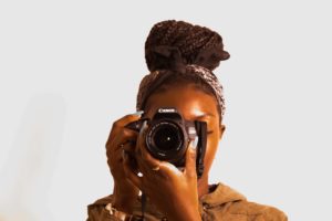 Woman practicing her skills with a camera. Thinking of becoming a professional photographer? Here's what you need to do