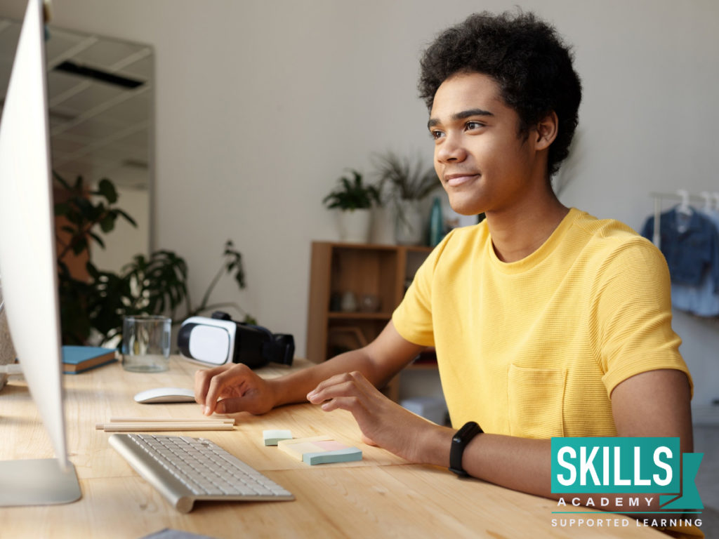 Boy wearing a yellow t-shirt, smiling in front of a computer, happy after his parents helped him with his online course. Help Your Kids Succeed at Distance Learning and they could reach all their study goals.