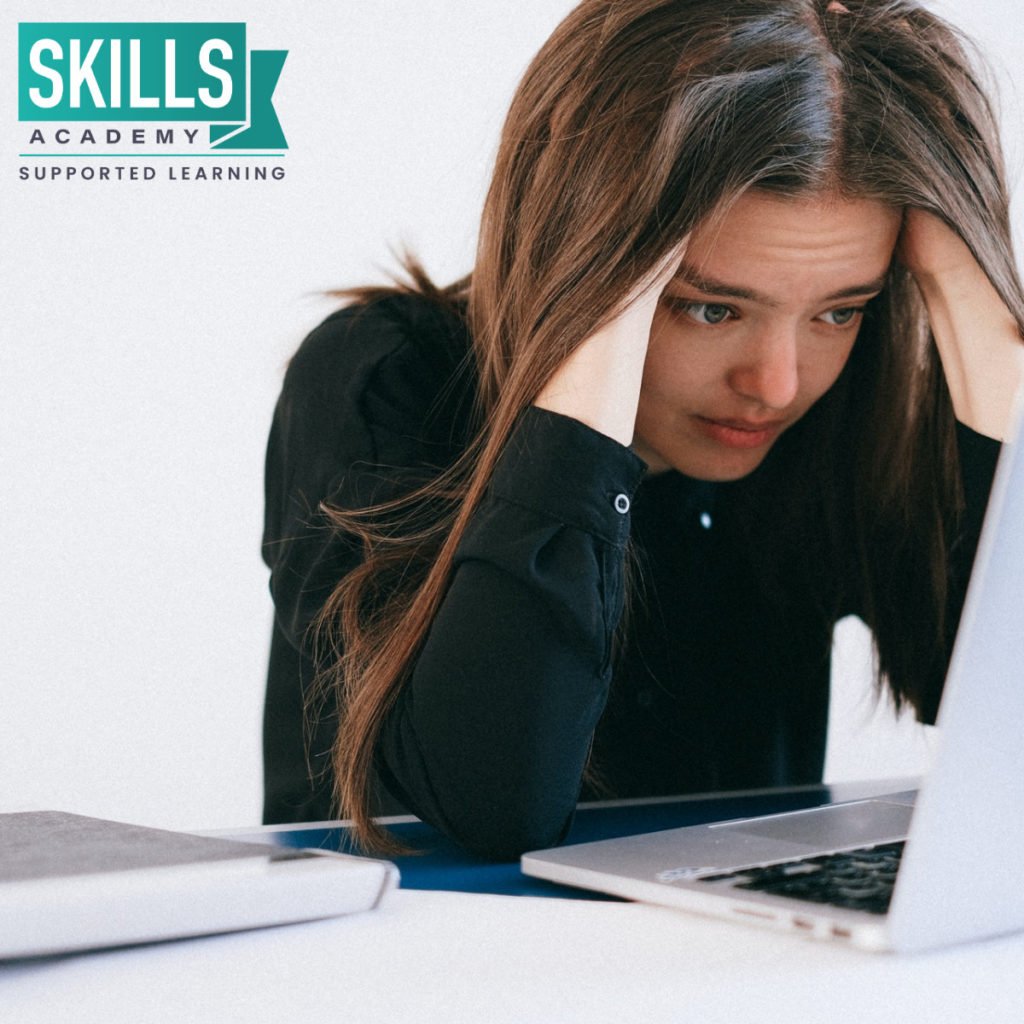 Stressed out student staring at her laptop. Let us help you learn How to Cope With Exam Stress.