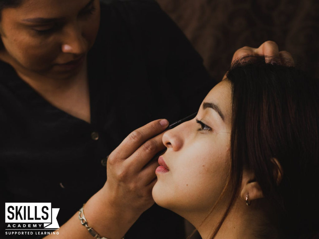 A makeup artist, doing a clients make-up. Look at the Creative Courses you can Study Without Matric.