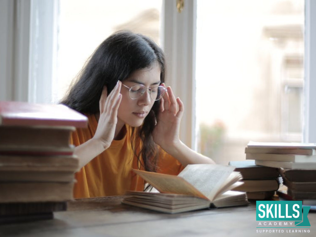 A matric student sitting with her books. Find tips on Revising for Your Matric Exams.