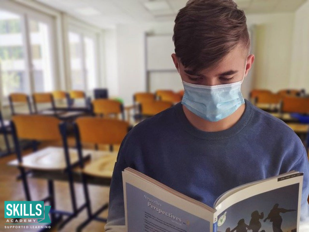 A student wearing a mask in his exam venue. Find tips to stay safe in your exam venue right here.