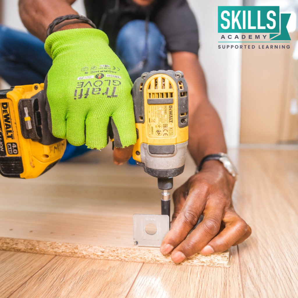 Man using a power drill to work. This should answer the question: Why Study Vocational Courses?