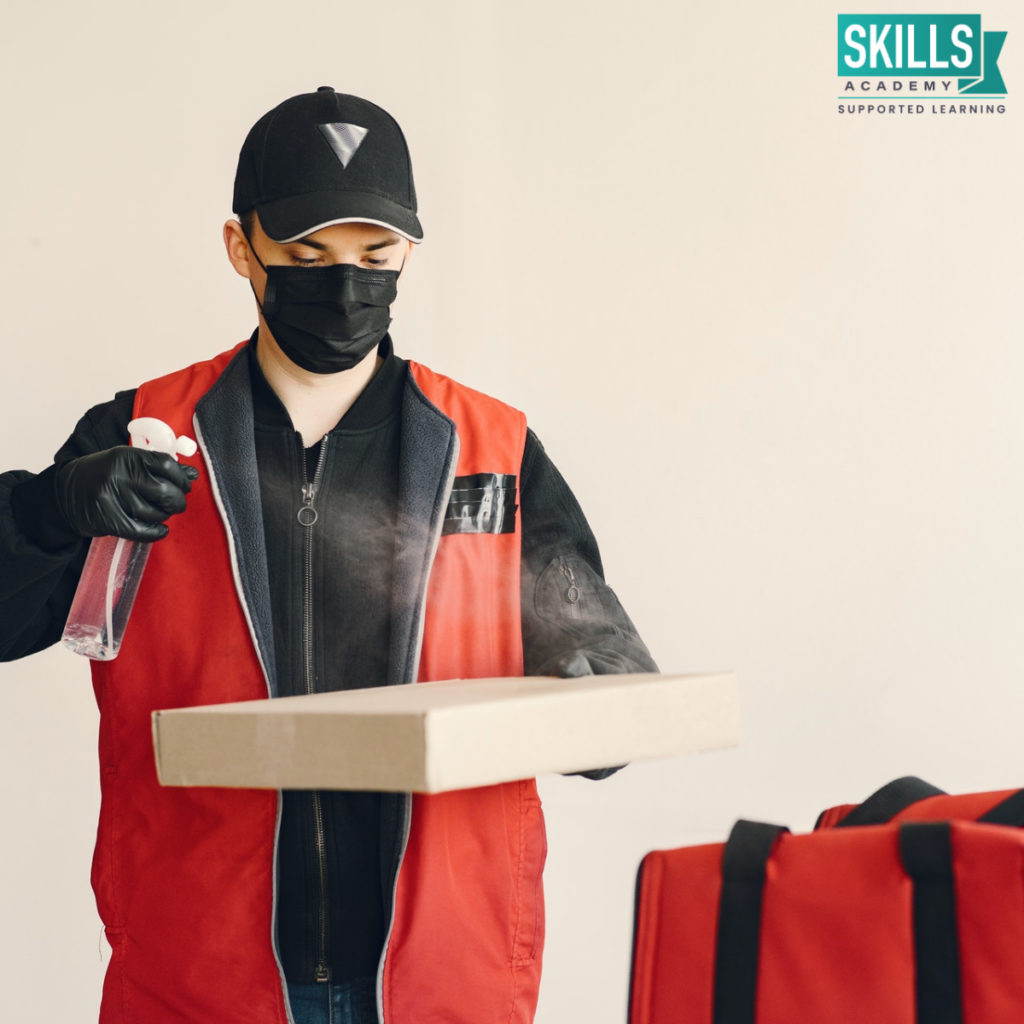Delivery man sanitising a package while wearing a mask. Find out Will Covid-19 Affect my Chances of Getting a Job and how learning new skills will help you land a stable job.