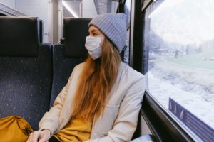 Woman on the train wearing a mask. What does the The Future of Tourism in 2021 have in store for us?