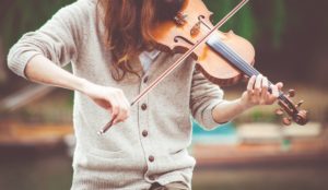 A student practicing her violin. Use our Music Past Papers to practice for your theoretical music exam.