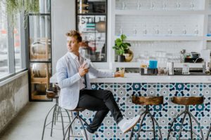 A professional sitting on a chair in a coffee shop. Find out How to Change Careers in the Covid Economy.