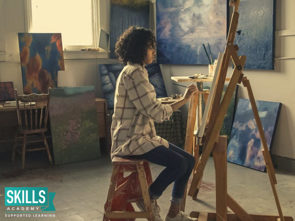 An artist painting on a canvas. Explore your creativity with these 5 Unique Careers in the art World.