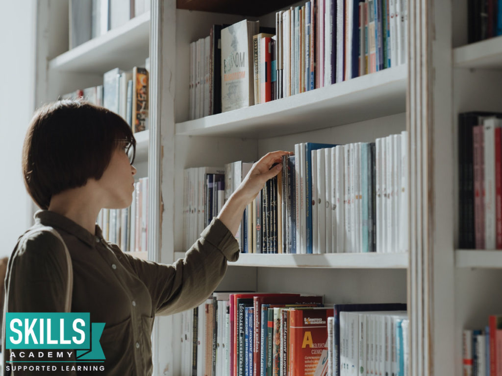 Student trying to pick a book to read. Use these tips on How to Improve Your Decision-Making Skills as a guide.