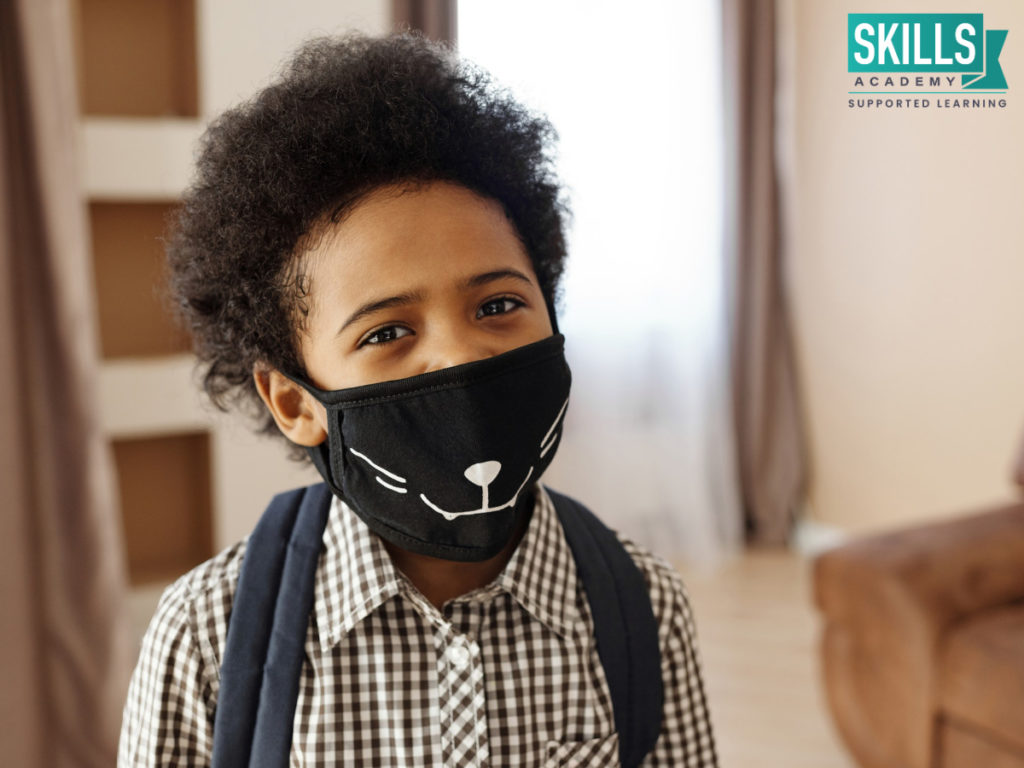 Boy wearing a black mask. The Impact of the Covid-19 Second Wave on Education has affected many students in South Africa.