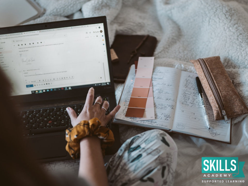 Person working from a laptop and using colour samples. Find more Low Stress Jobs That Pay Well here.