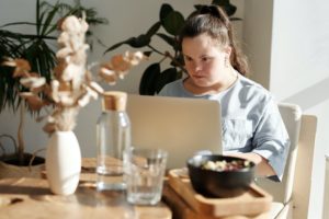 Woman sitting around the table with her laptop. Here's How to Find Remote Jobs