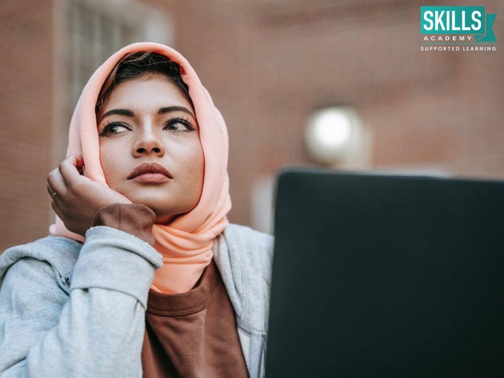 A student holding her chin wondering how to pay off student loans.