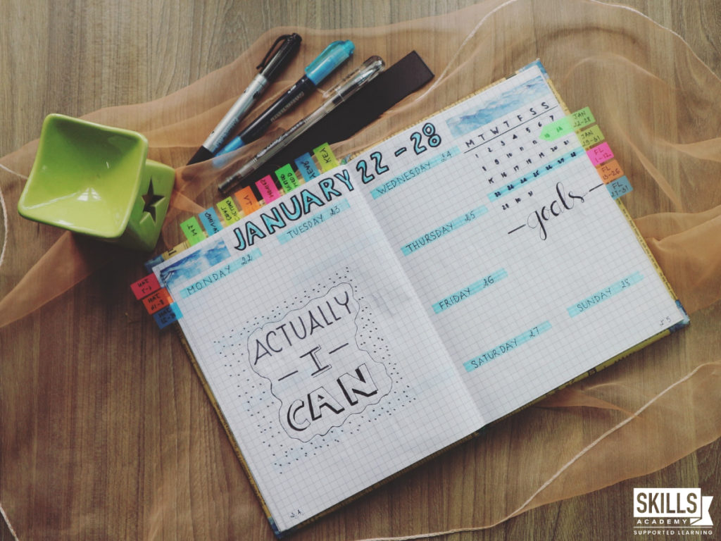 Study schedule and stationary on a table. Creating a study schedule and daily planner are one of our top tips to completing your assignments.