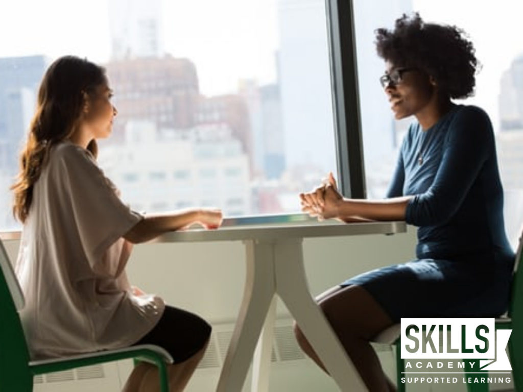 Two women sitting down together, disscusing career vs job - the key differences.