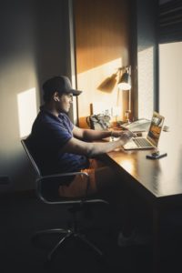 A young man sittting at his computer looking at what to do when you are unemployed