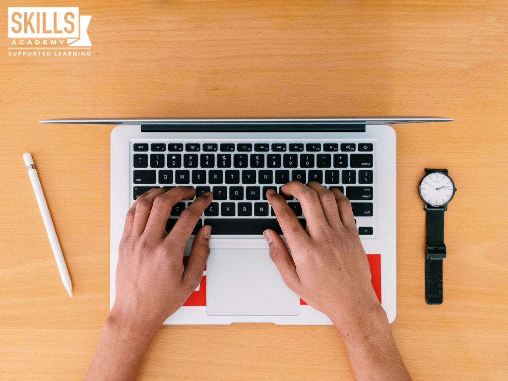 Person typing on a laptop with a watch next to them. Should you Study Matric Part-time? Find out here.