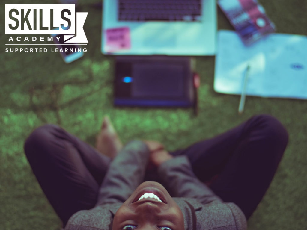 Woman working on her laptop and is busy smiling. This is why positivity is crucial in the workplace