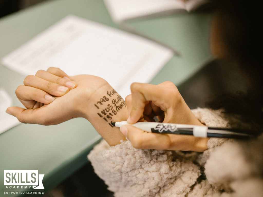 Student cheating by writing down the answers on her wrist. Learn all about the consequences of cheating during exams right here.