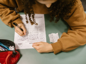 Student cheating during her exam using crib notes. The consequences of cheating during exams are serious and could set you back in your studies.